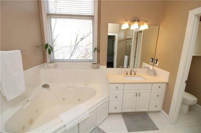 bathroom with tile patterned floors, toilet, vanity, and a whirlpool tub