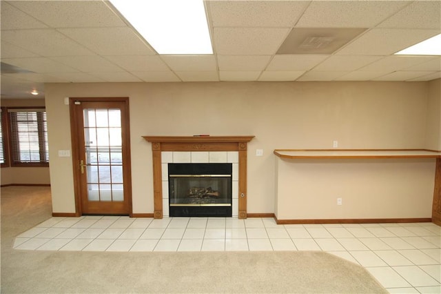 unfurnished living room with tile patterned floors, a paneled ceiling, and carpet floors