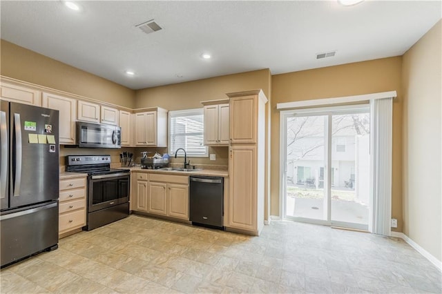 kitchen with visible vents, light brown cabinets, stainless steel appliances, and a sink