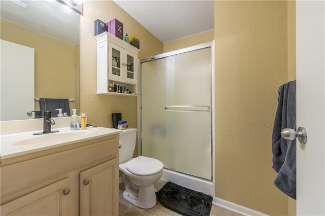 full bath featuring a shower stall, toilet, vanity, and a textured wall