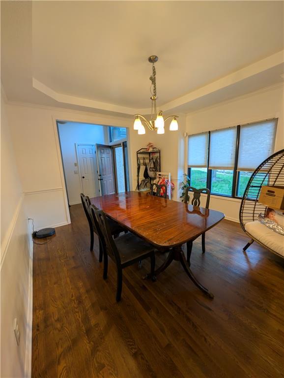 7730 N Shannon Ave, Kansas City, MO 64152 - dining area with wood finished floors, a chandelier, and a raised ceiling
