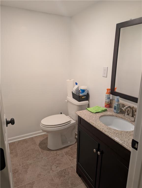 7730 N Shannon Ave, Kansas City, MO 64152 - half bathroom with toilet, vanity, and tile patterned floors