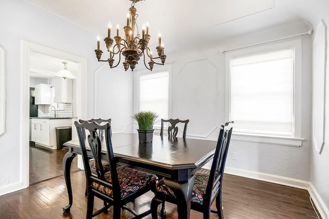 dining space with baseboards, plenty of natural light, a notable chandelier, and dark wood-style flooring