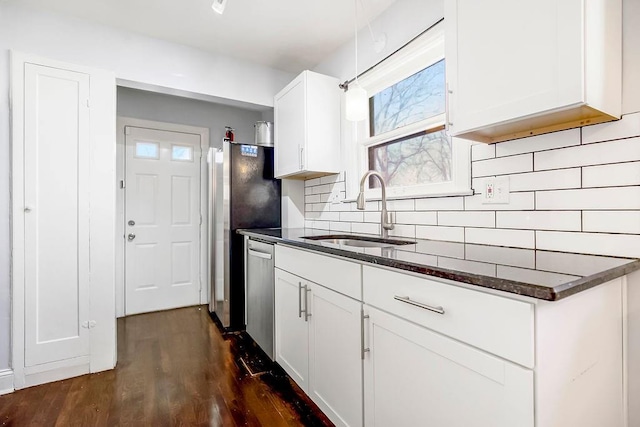 kitchen with stainless steel appliances, decorative backsplash, dark wood-type flooring, white cabinets, and a sink