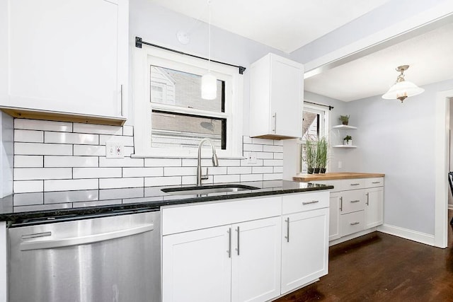 kitchen featuring decorative light fixtures, decorative backsplash, stainless steel dishwasher, white cabinetry, and a sink