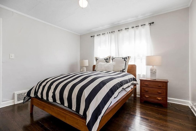 bedroom featuring baseboards, wood-type flooring, and ornamental molding