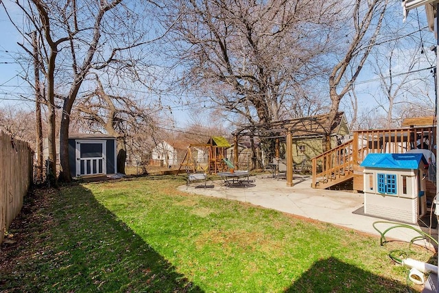 view of yard with a fenced backyard, a patio area, a playground, and an outdoor structure