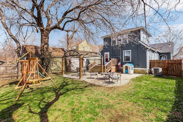 view of yard with a fenced backyard, central AC unit, a playground, and a patio