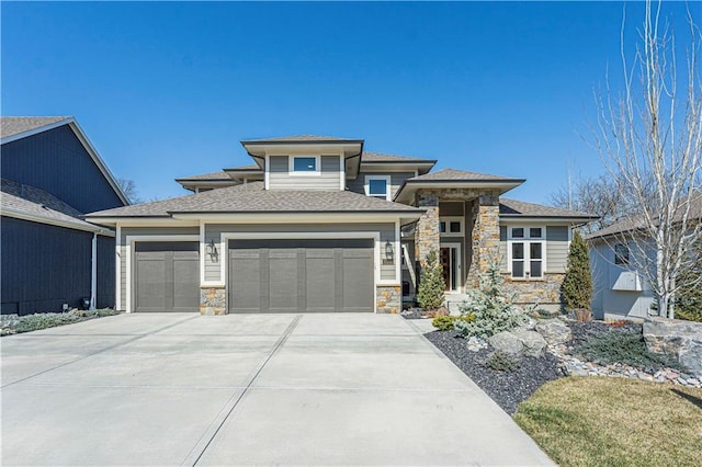 prairie-style home with a garage, stone siding, and driveway