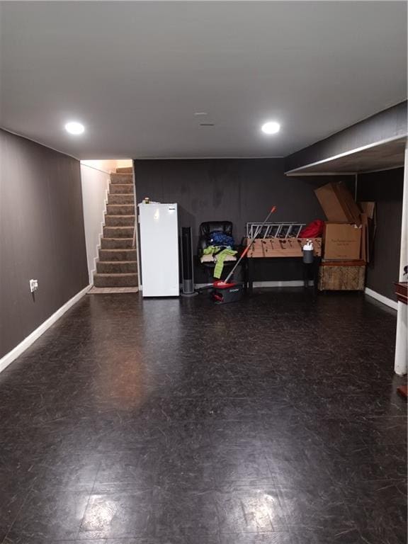 finished basement featuring stairway, baseboards, recessed lighting, freestanding refrigerator, and tile patterned floors