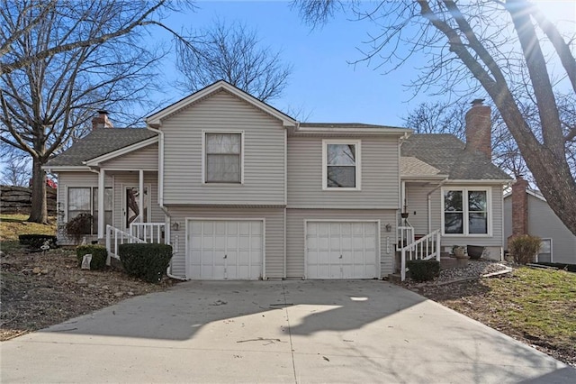 tri-level home featuring driveway, a chimney, and a garage