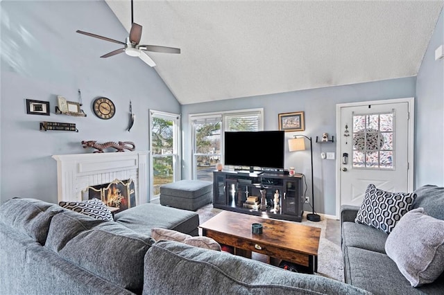 living room with baseboards, lofted ceiling, ceiling fan, a textured ceiling, and a brick fireplace