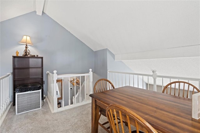 carpeted dining space with vaulted ceiling with beams