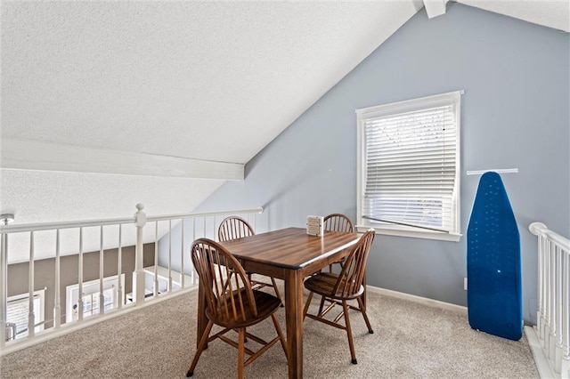 dining room featuring vaulted ceiling, carpet flooring, baseboards, and a textured ceiling