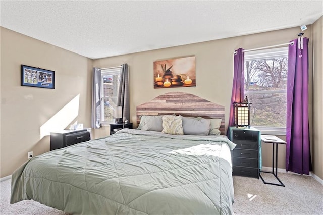 bedroom with carpet, baseboards, and a textured ceiling