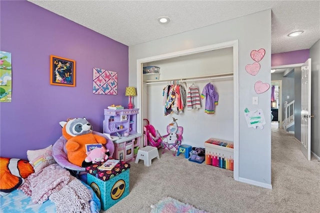 carpeted bedroom featuring baseboards, a closet, and a textured ceiling