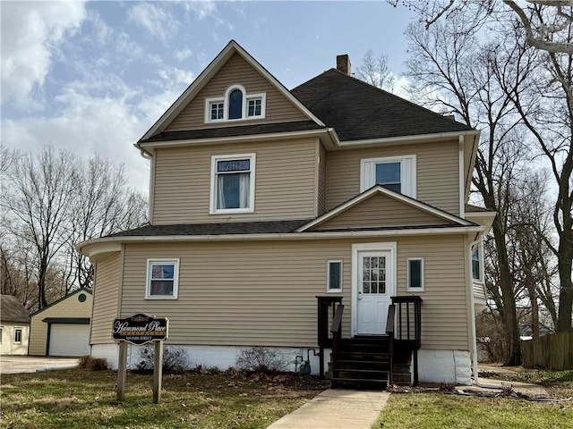 view of front of home with entry steps, a chimney, an outdoor structure, and roof with shingles