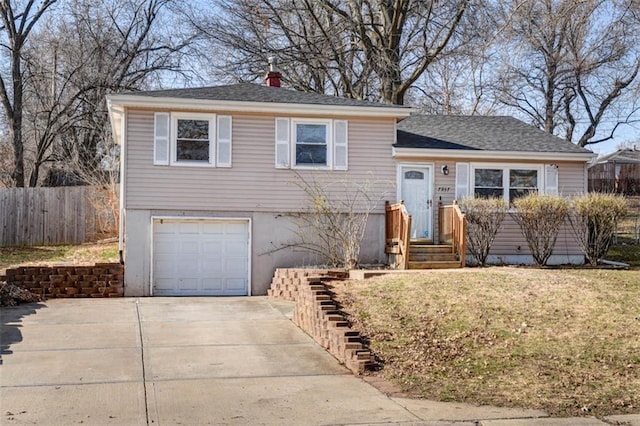 tri-level home with a garage, a chimney, driveway, and fence