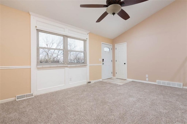 unfurnished room with vaulted ceiling, visible vents, and light carpet