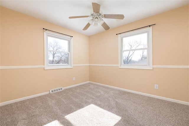 empty room featuring visible vents, baseboards, carpet floors, and ceiling fan