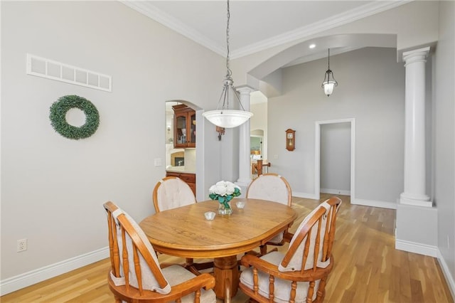 dining room with decorative columns, light wood-style floors, visible vents, and ornamental molding