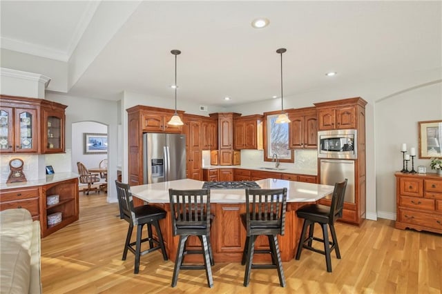 dining room with recessed lighting, light wood-style flooring, arched walkways, and ornamental molding