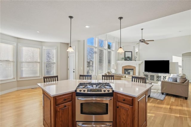 kitchen with plenty of natural light, light wood-style flooring, stainless steel gas range, and light countertops