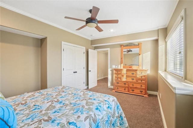 carpeted bedroom with ceiling fan, baseboards, a closet, and ornamental molding