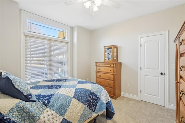 bedroom featuring baseboards, light carpet, and a ceiling fan