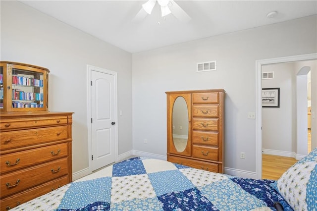 bedroom featuring visible vents, arched walkways, and baseboards