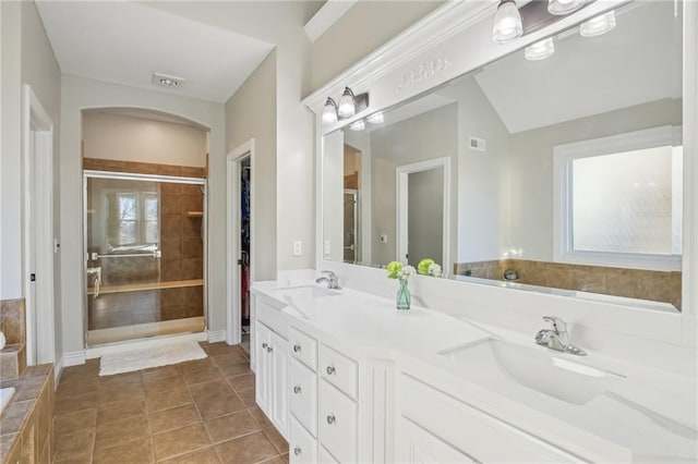 full bathroom with a garden tub, a stall shower, tile patterned floors, and a sink