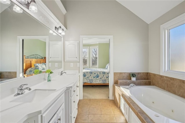 full bath with ensuite bath, vaulted ceiling, a wealth of natural light, and a sink