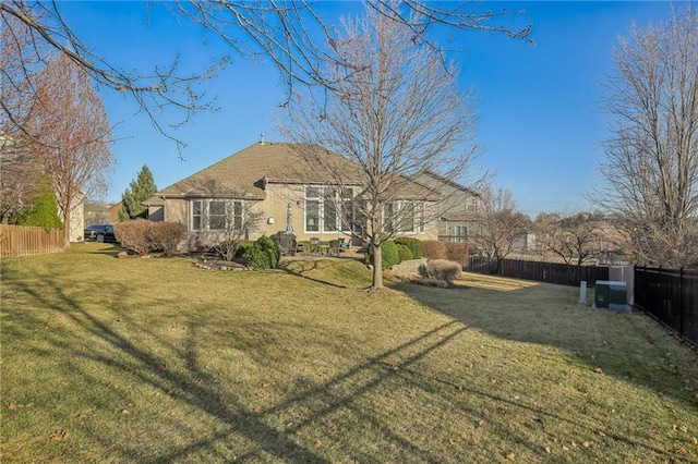 rear view of property with a lawn and fence