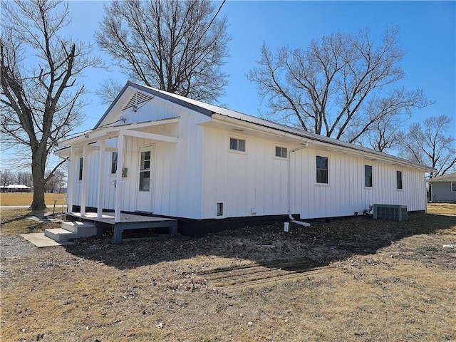 view of side of property with central air condition unit, board and batten siding, and metal roof