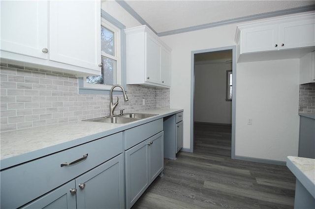 kitchen featuring a sink, decorative backsplash, dark wood-type flooring, and white cabinets