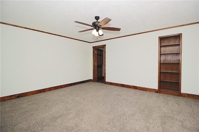 unfurnished room with baseboards, a textured ceiling, crown molding, and carpet