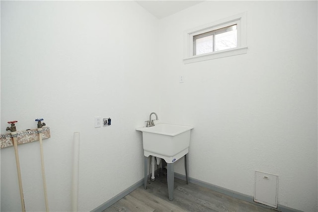 laundry area featuring light wood-style flooring, baseboards, hookup for a washing machine, and laundry area