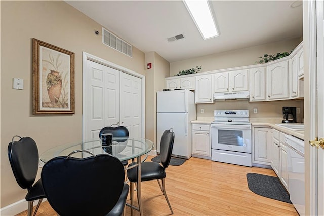 kitchen with white cabinetry, white appliances, visible vents, and under cabinet range hood