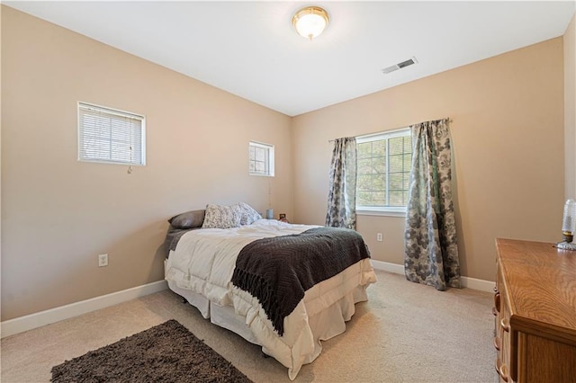 bedroom with visible vents, light colored carpet, and baseboards