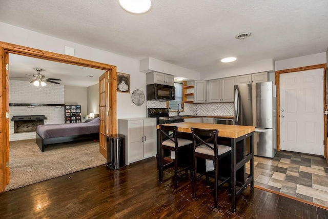 kitchen with dark wood-style floors, open shelves, gray cabinets, black appliances, and backsplash