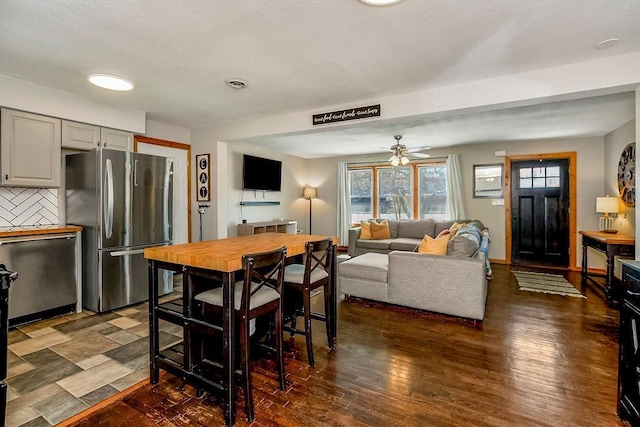 dining area featuring baseboards, wood finished floors, visible vents, and ceiling fan