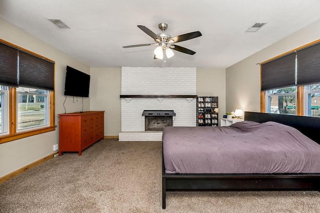 bedroom with a fireplace, carpet, visible vents, and baseboards