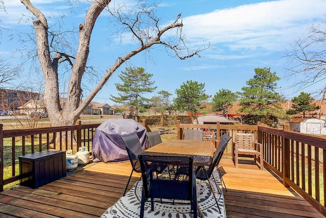 wooden terrace with grilling area and outdoor dining space