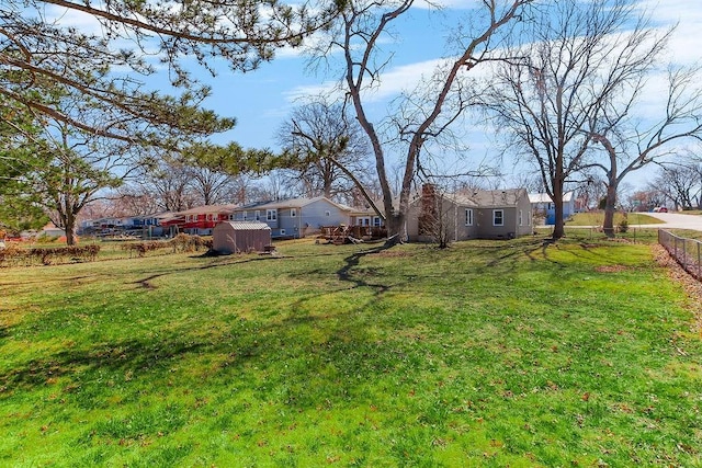 view of yard featuring a storage shed, an outdoor structure, and fence