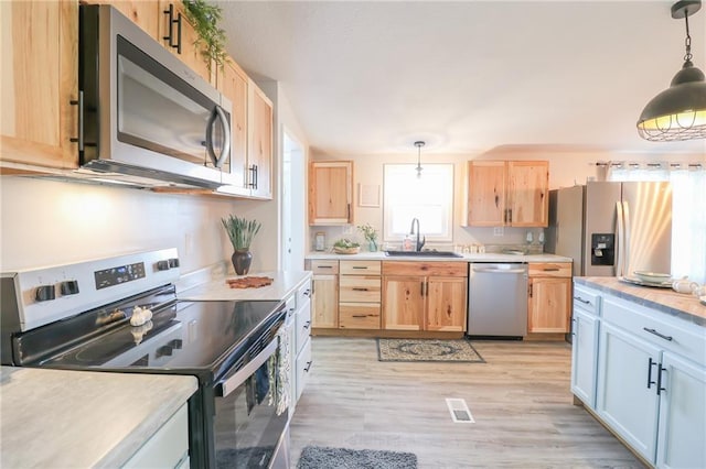 kitchen with visible vents, light brown cabinetry, a sink, appliances with stainless steel finishes, and light countertops