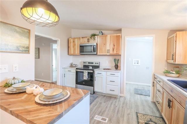 kitchen featuring a sink, visible vents, appliances with stainless steel finishes, and light brown cabinetry