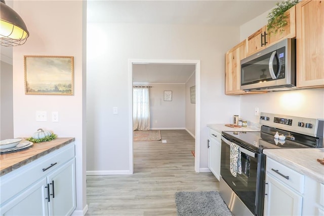 kitchen with baseboards, light brown cabinetry, light countertops, light wood-style flooring, and appliances with stainless steel finishes