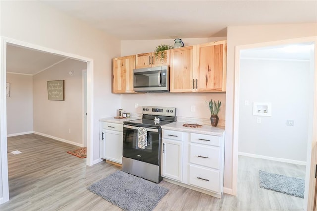 kitchen with lofted ceiling, light countertops, and stainless steel appliances