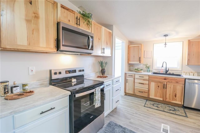 kitchen with a sink, appliances with stainless steel finishes, and light brown cabinets