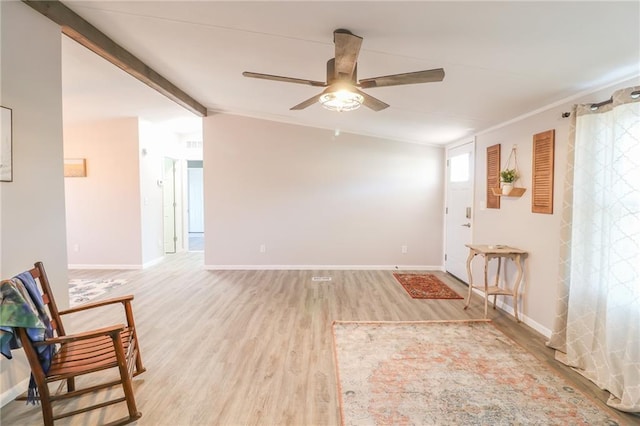 interior space featuring lofted ceiling with beams, light wood-type flooring, baseboards, and a ceiling fan